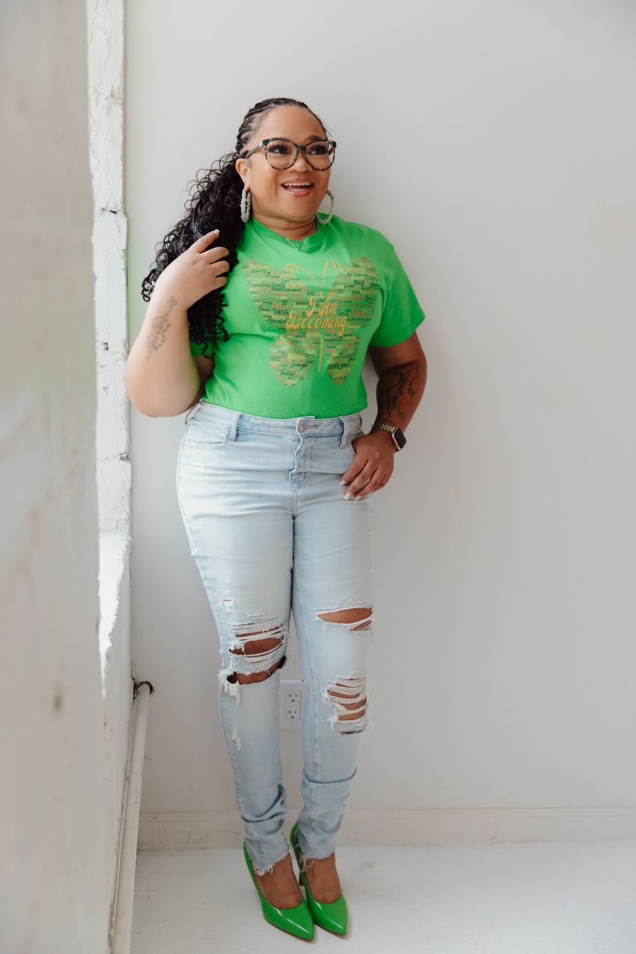 Coach Tara wearing the I Am Becoming butterfly T-shirt